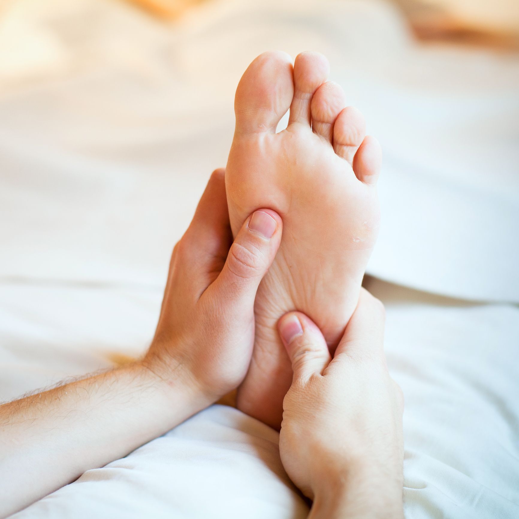 A person is getting a foot massage on a bed.