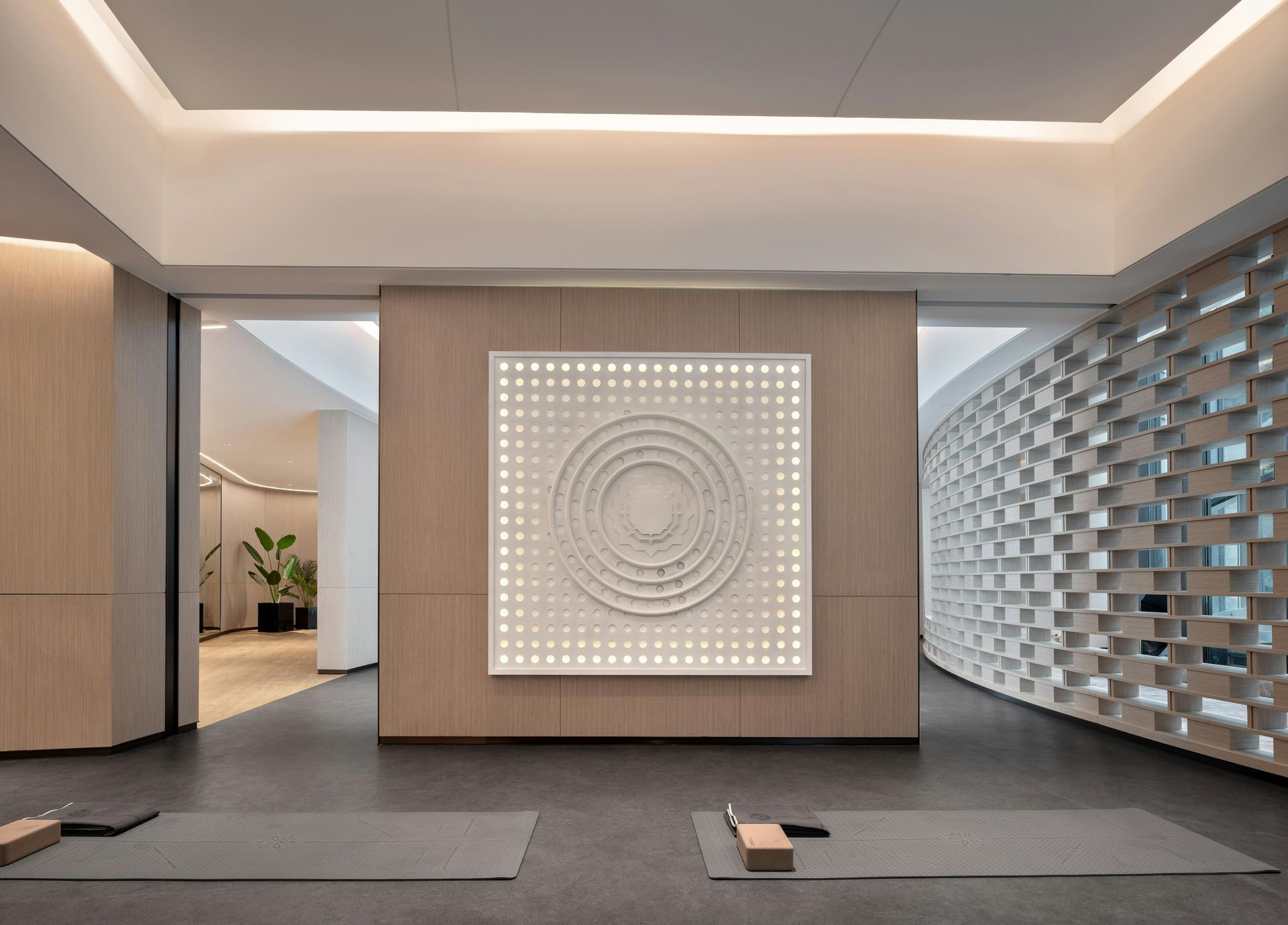 Modern minimalist lobby with geometric wall art, gray carpet, and patterned tile wall.