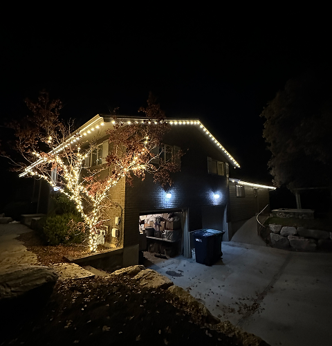 House at night decorated with white Christmas lights.