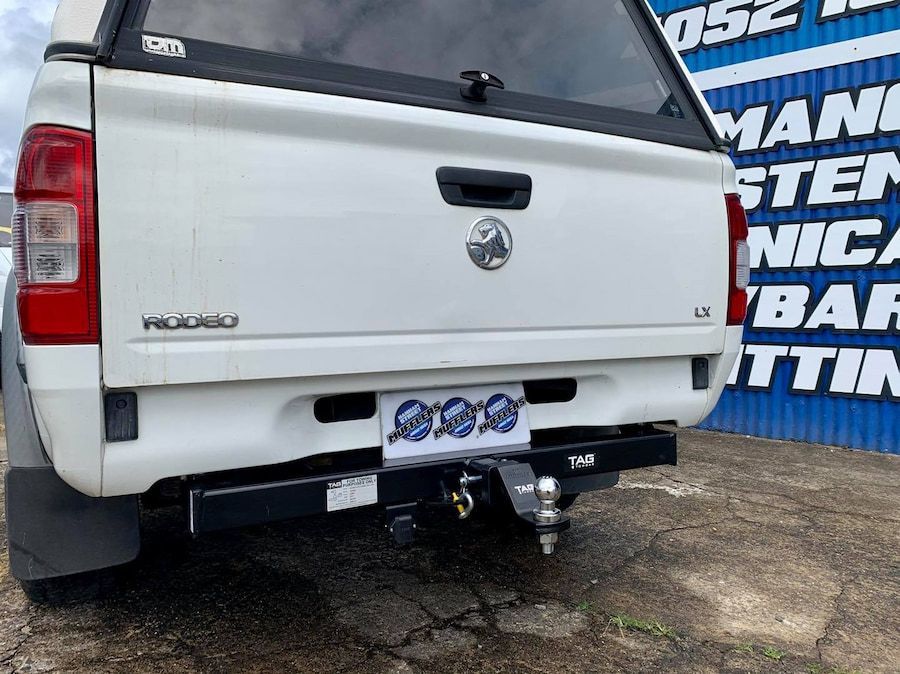 A White Pickup Truck With A Tow Bar Attached To The Back — Hannam Street Mufflers and Mechanical In Bungalow, QLD
