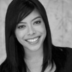 A black and white photo of a smiling woman with long hair.