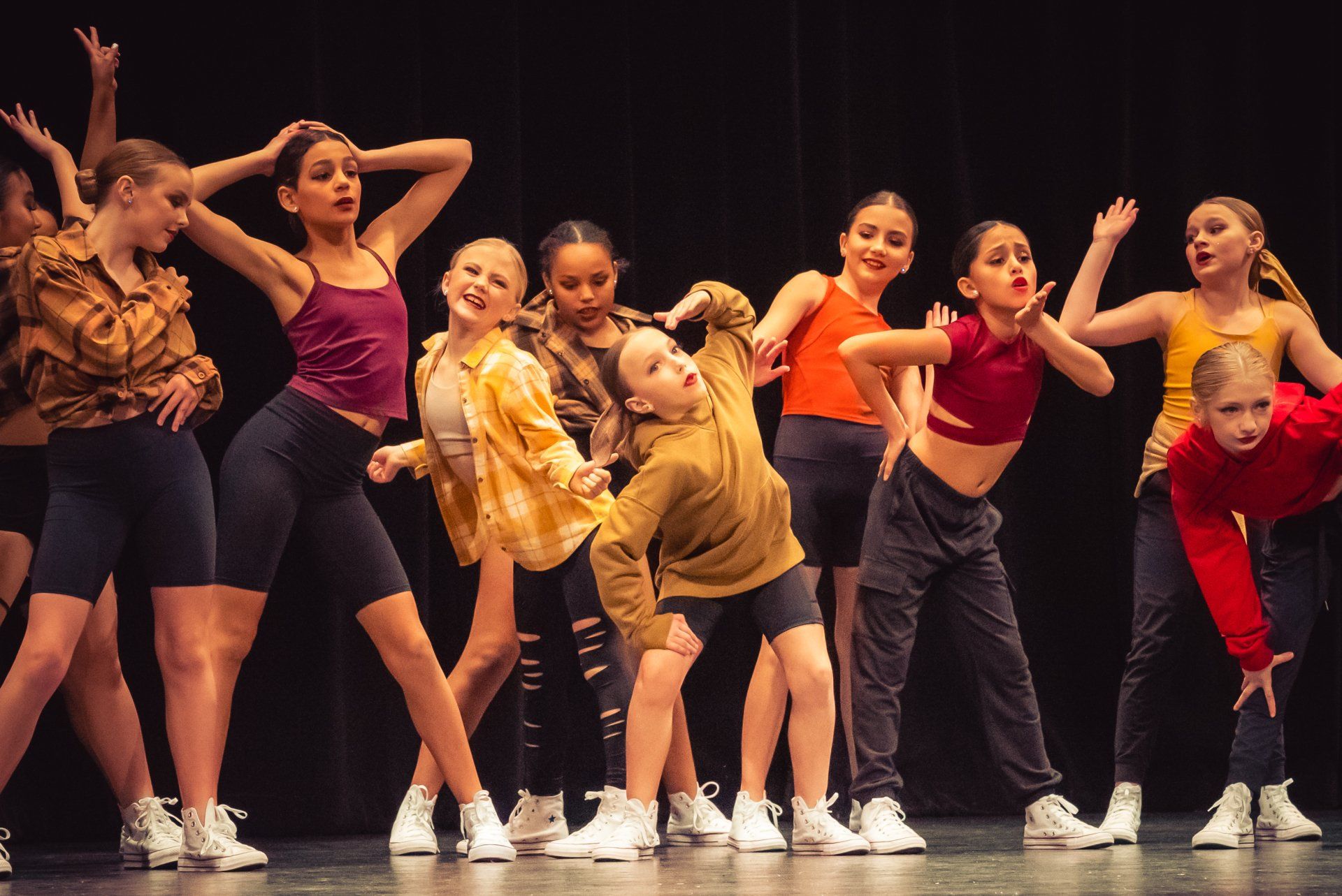 A group of young dancers are performing on a stage.