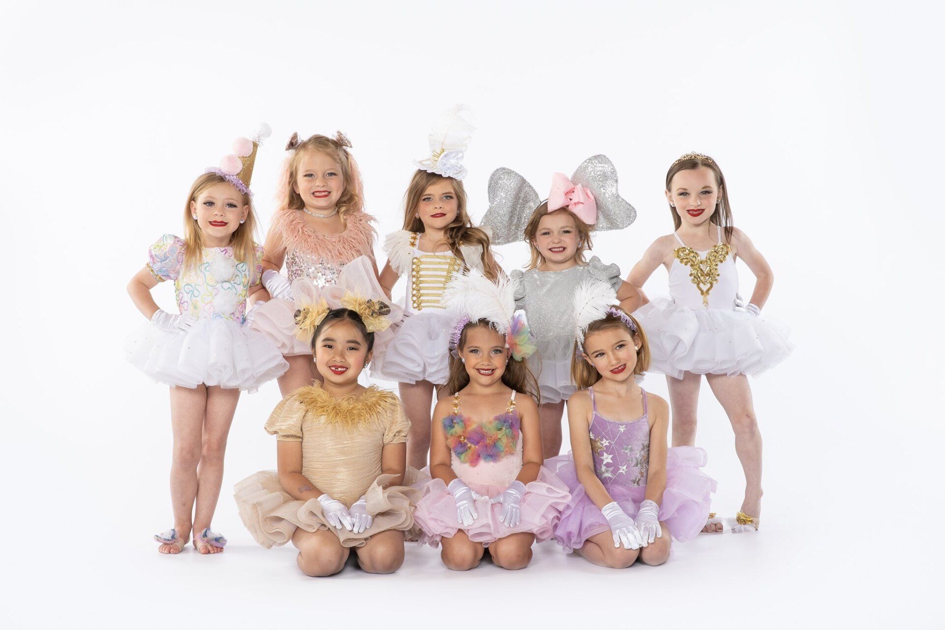 A group of young girls dressed in costumes are posing for a picture.