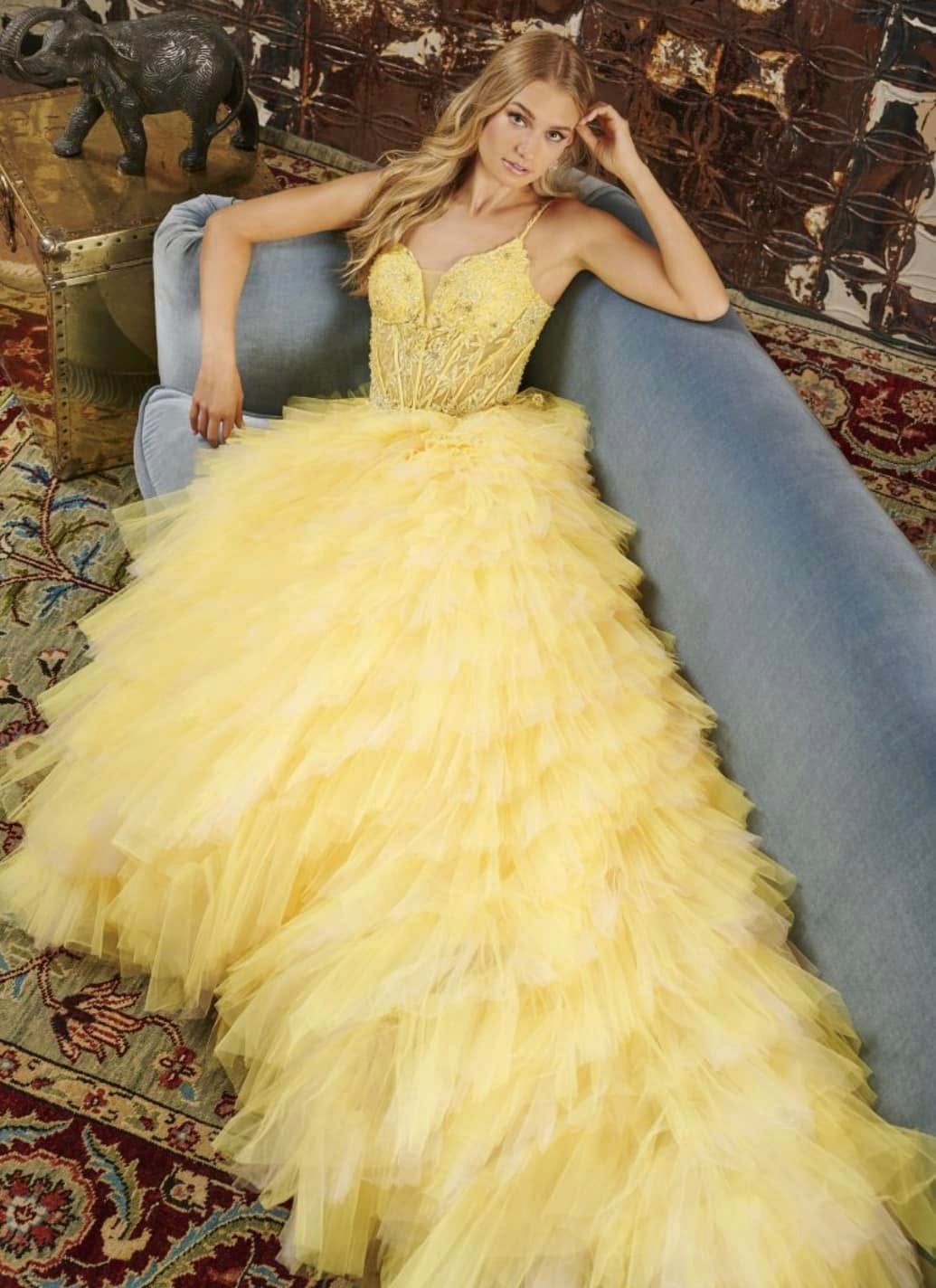 Woman in a yellow gown reclining on a blue sofa in an ornate room