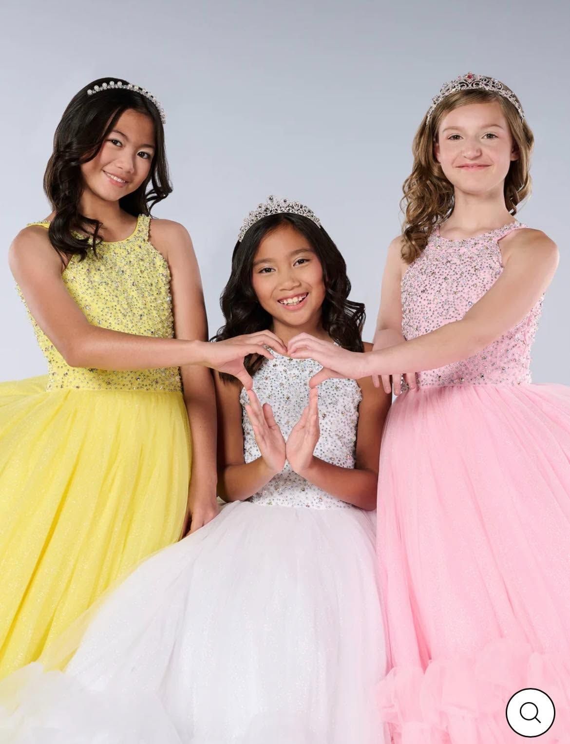 Three girls in formal dresses posing together against a light studio backdrop.