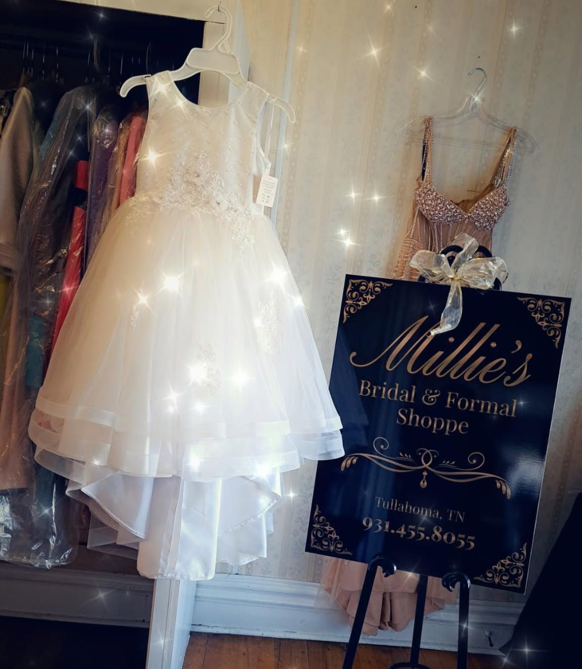 White dress on display in a bridal shop beside a Millie’s Bridal & Formals sign
