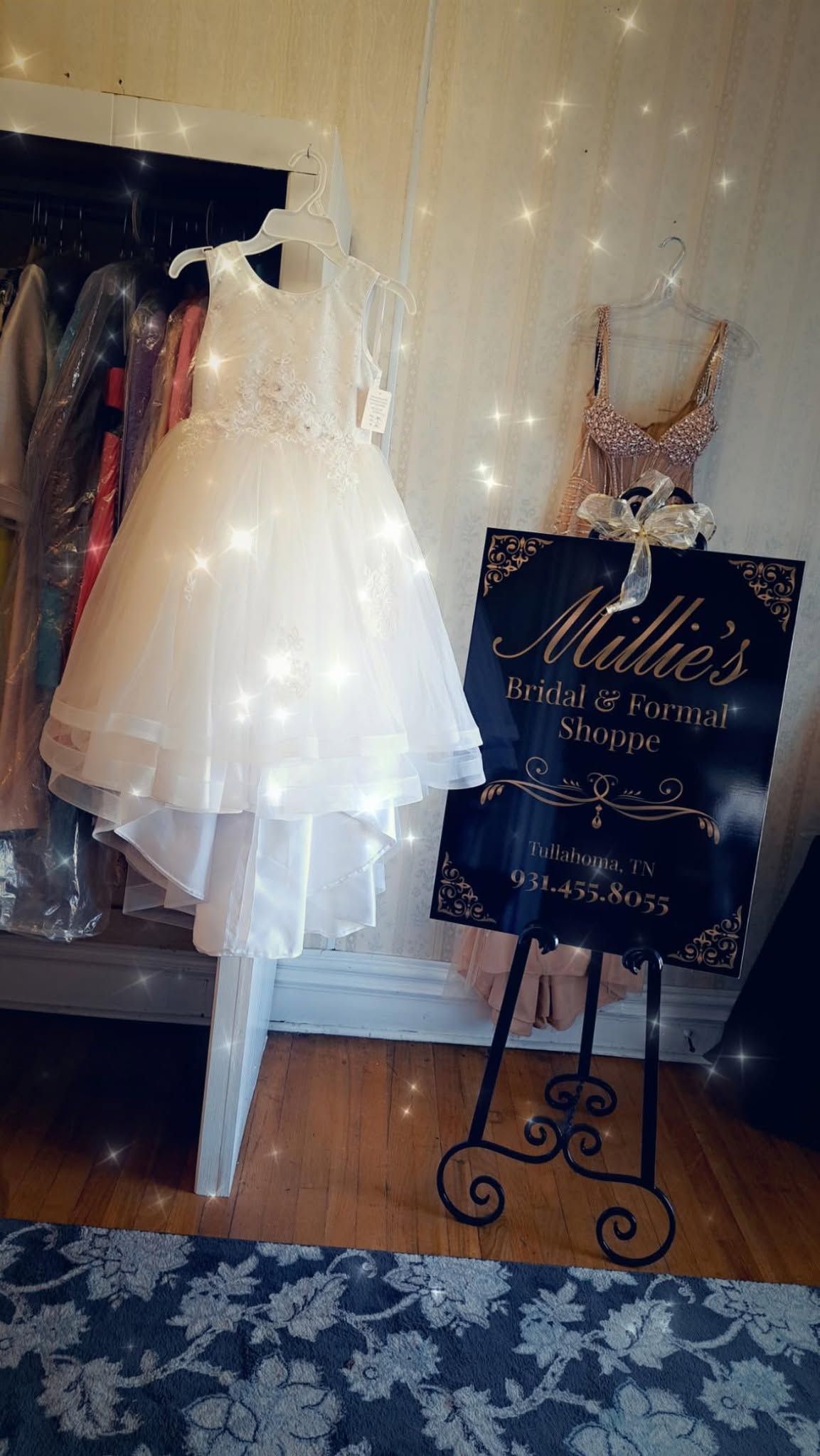 White dress on mannequin beside decorative easel sign in a boutique-like room