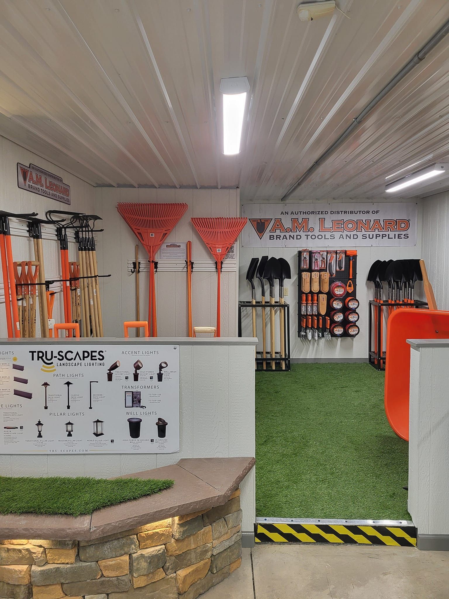 Indoor fitness obstacle course with orange equipment, turf, and wall-mounted grips under bright ceiling lights