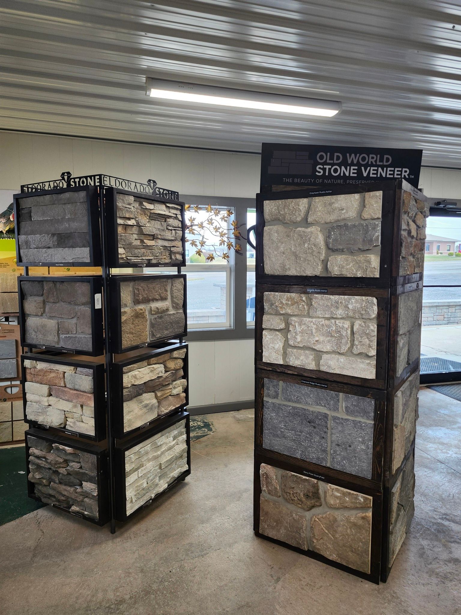 Two stone display pillars in a bright indoor room, each showing sample stone blocks and labels.