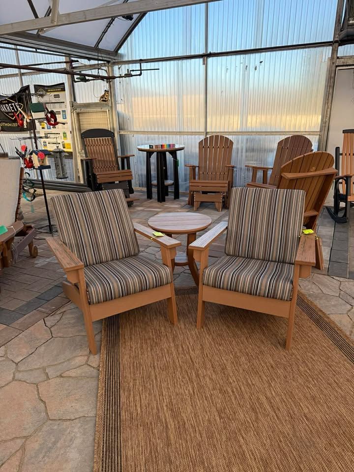 Two striped patio chairs on a woven rug in a sunlit outdoor seating area.