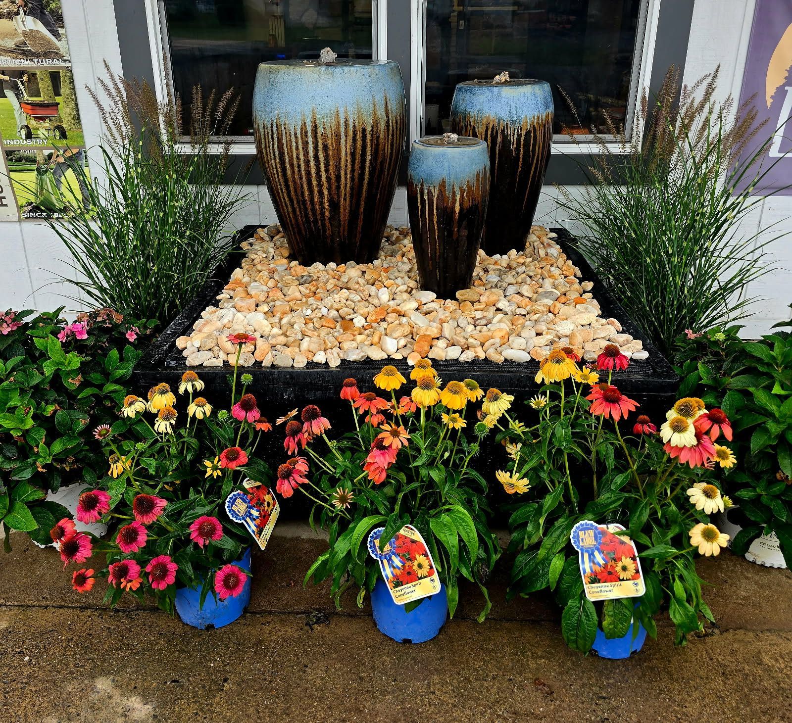 Colorful flower display with decorative pots and garden stones in front of a window