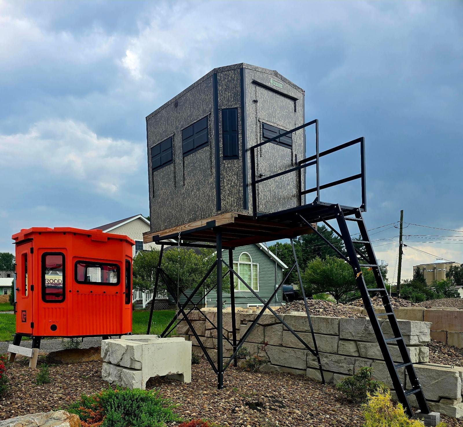Orange railcar beside a raised gray watchtower on a cloudy outdoor site