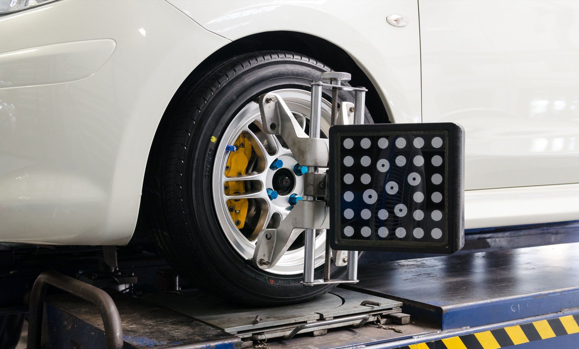 Car wheel on alignment machine with sensor target beside the tire
