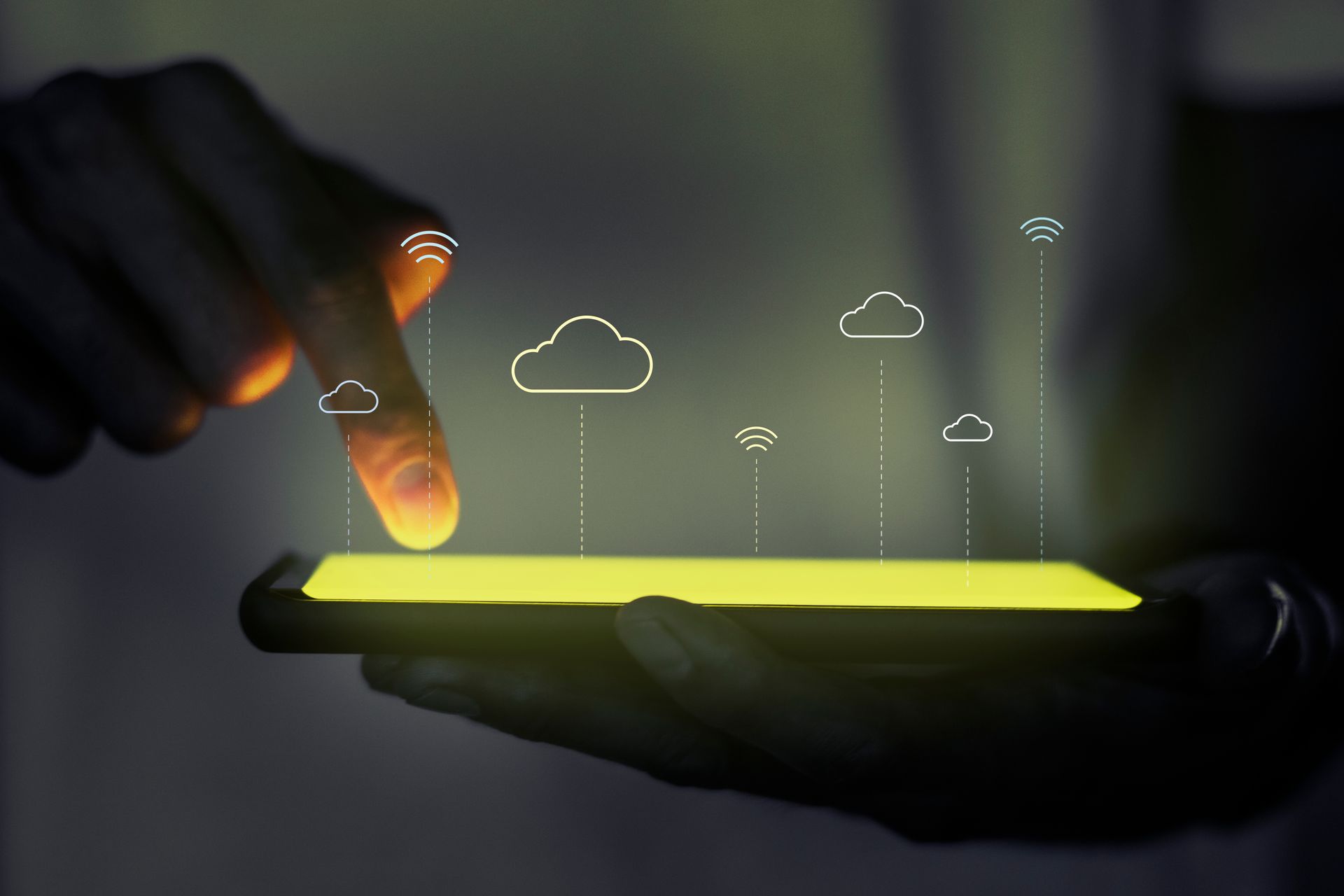 Main tenant un smartphone, le doigt touchant l'écran, sur lequel se superposent des icônes de nuages lumineux.