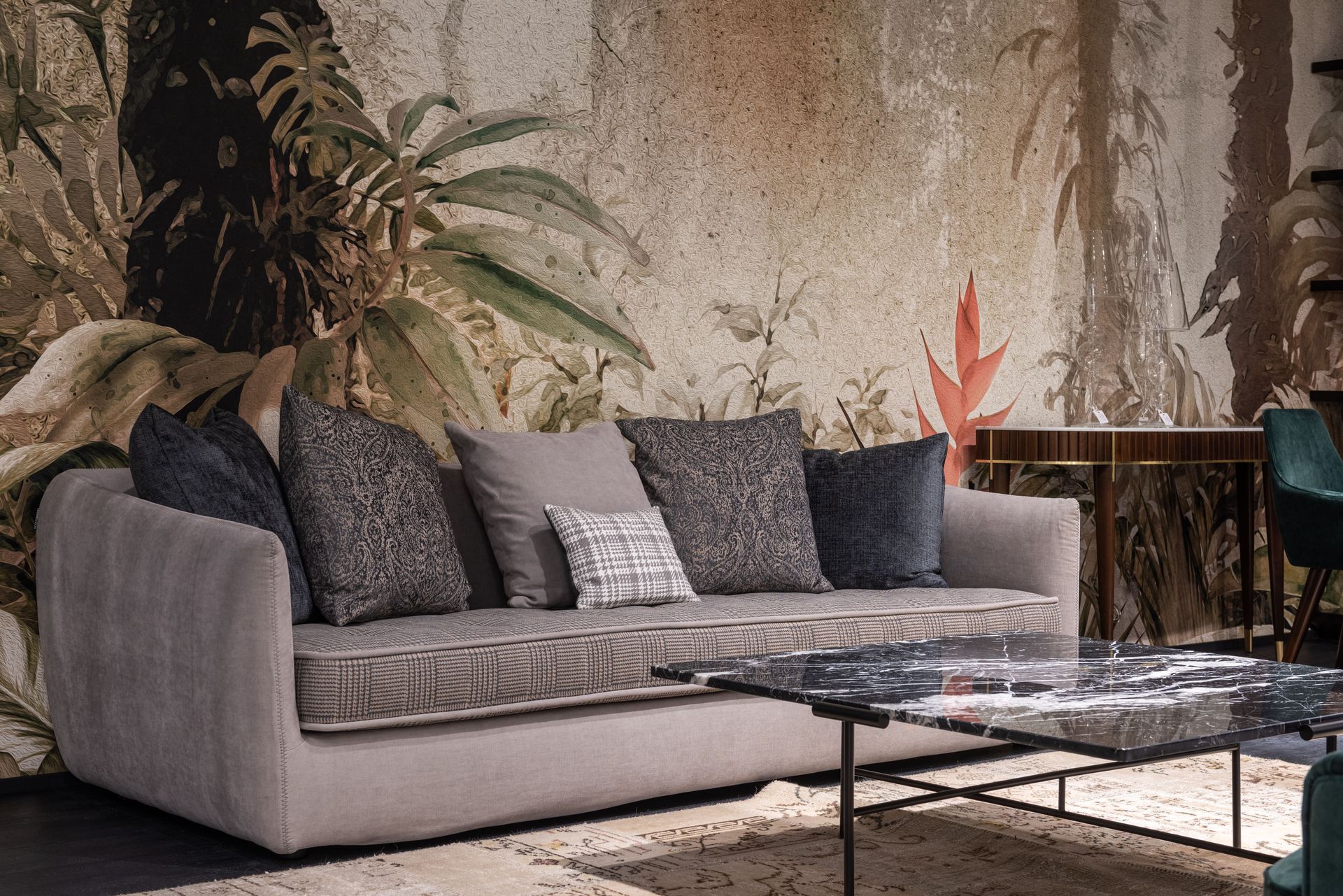 Gray sofa with dark pillows in a cozy outdoor patio beside a coffee table and plants