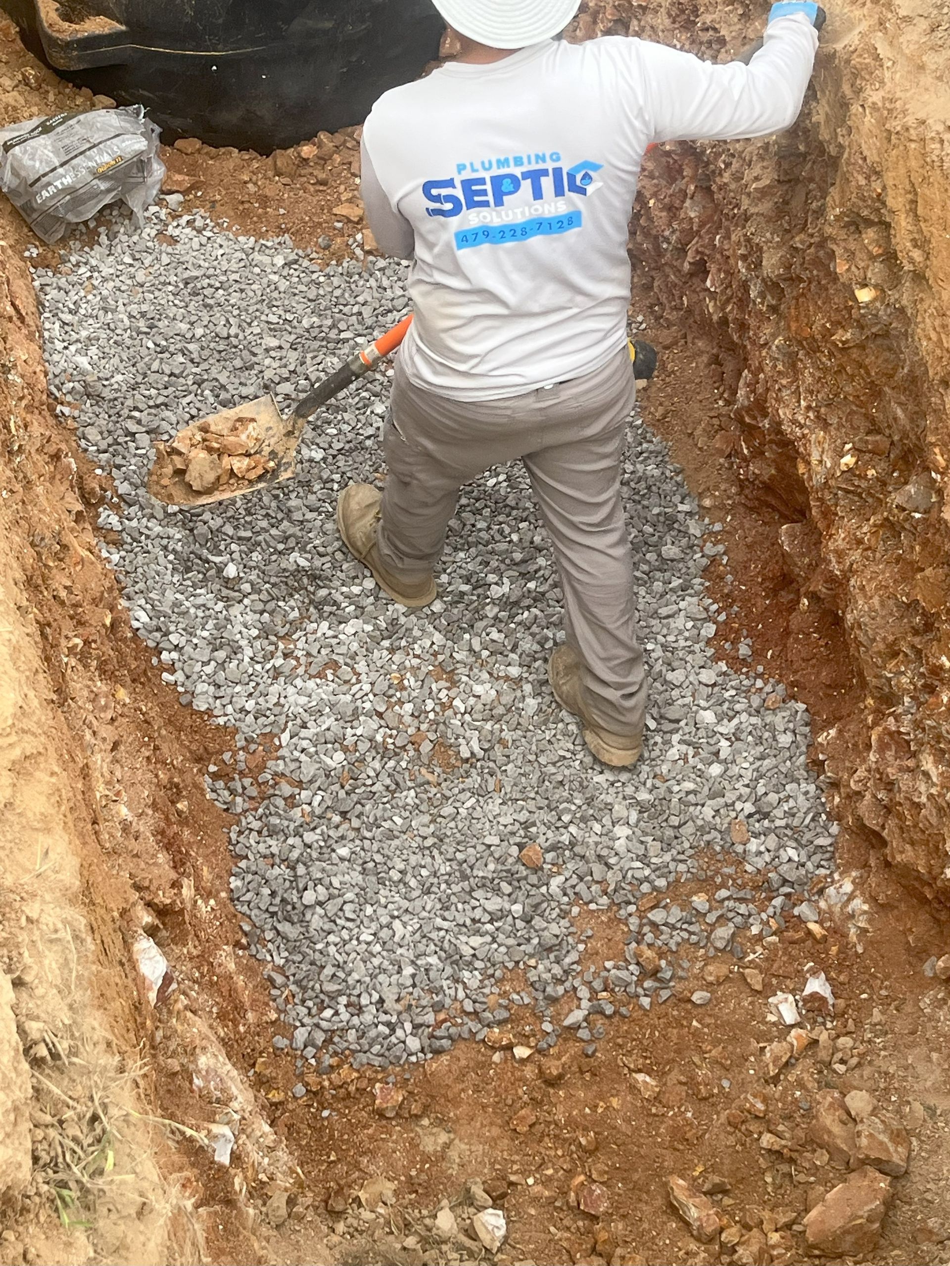 A man is digging a hole in the ground with a shovel.