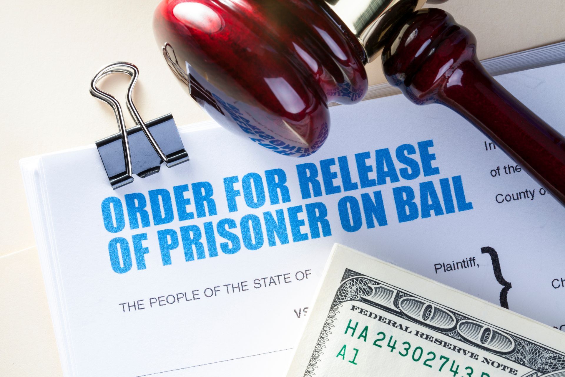Bail bond release authorization document beside gavel and cash on desk.