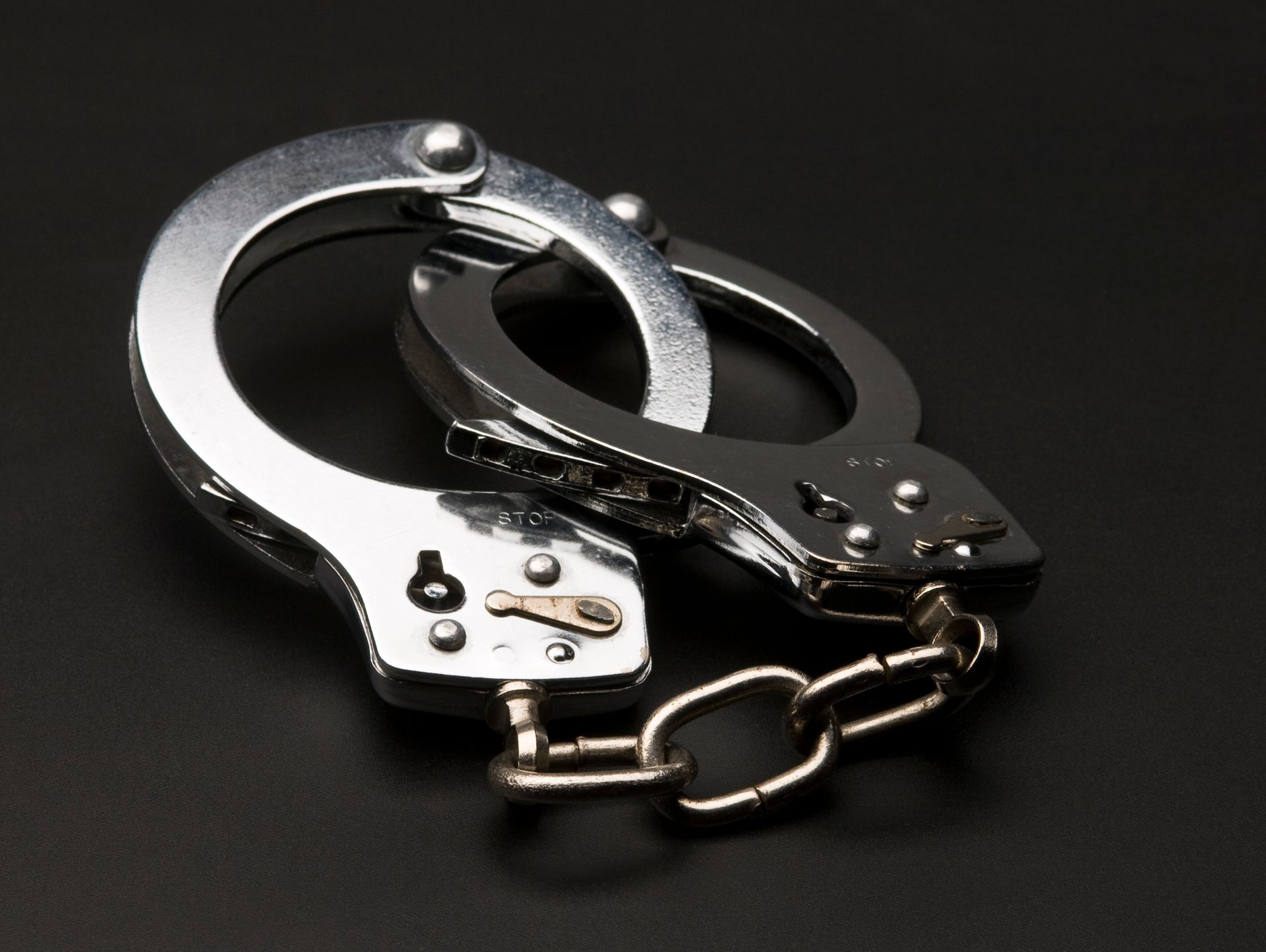 A pair of handcuffs on a black surface