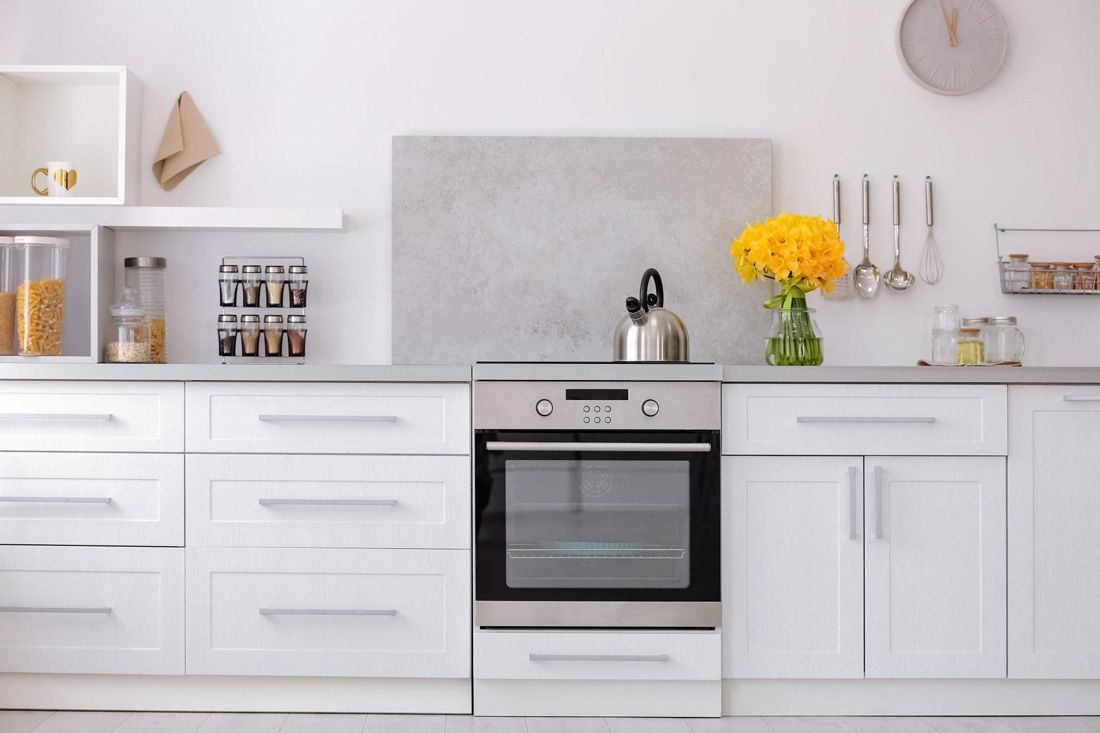 A Kitchen With White Cabinets, Oven and a Stove — A.S.A.P. Appliance Service & Sales in Hamlyn Terrace, NSW