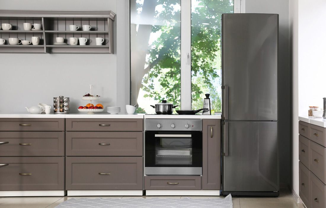 A Kitchen With Stainless Steel Appliances and Wooden Cabinets — A.S.A.P. Appliance Service & Sales in Toukley, NSW