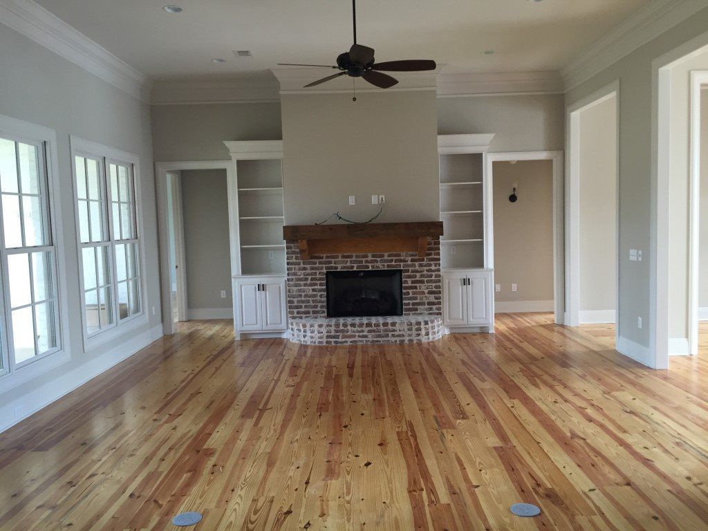 A living room with a fireplace and a ceiling fan