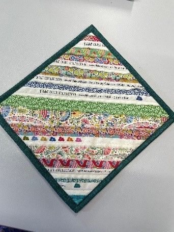 A Quilt With a Green Border is Sitting on a Table — Lyn-Jelle Crafts in Emu Park, QLD