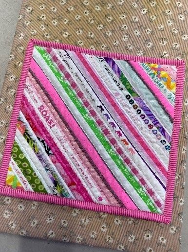 A Quilt With a Pink Border is Sitting on Top of a Piece of Fabric — Lyn-Jelle Crafts in Emu Park, QLD