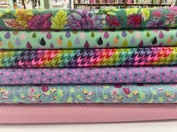 A Stack of Colorful Fabrics Sitting on Top of Each Other on a Table — Lyn-Jelle Crafts in Emu Park, QLD
