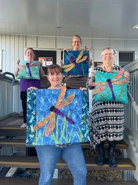 People Holding Dragonfly Pillows — Arts & Crafts in Emu Park, QLD