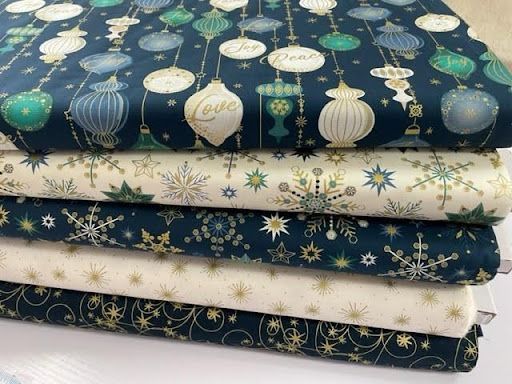 A Stack of Fabrics With Christmas Ornaments and Snowflakes on Them — Lyn-Jelle Crafts in Emu Park, QLD