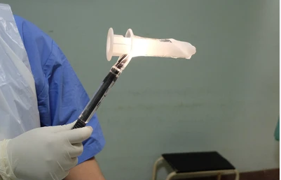 A doctor is holding a candle in their hand.