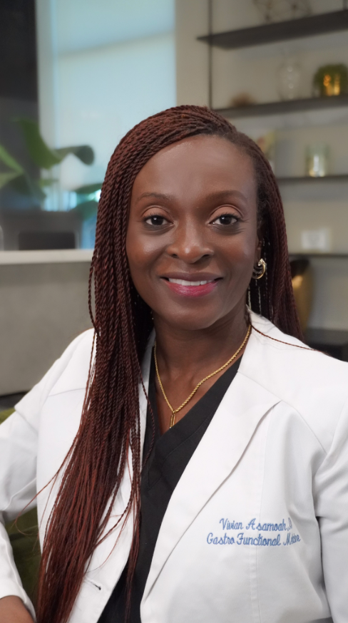A woman in a lab coat is smiling for the camera.