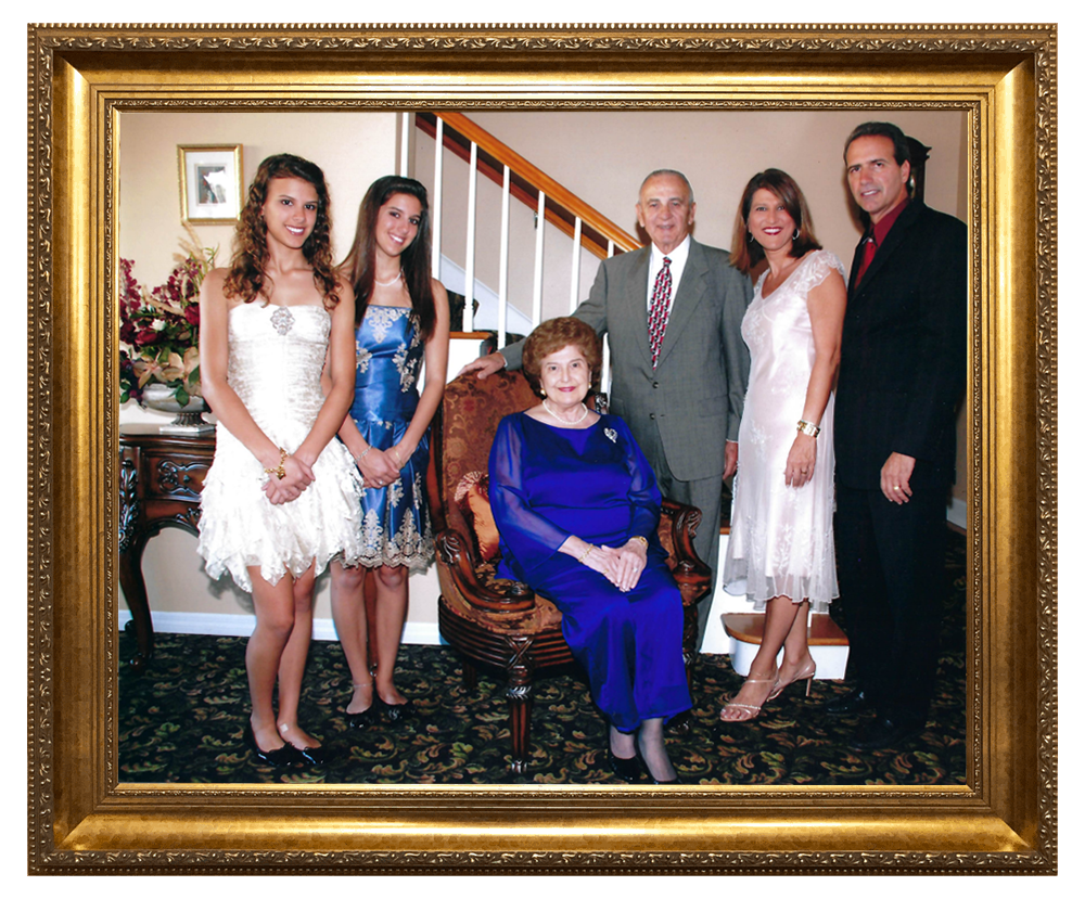 Family portrait: Woman in blue seated, others standing, formal attire, gold frame.