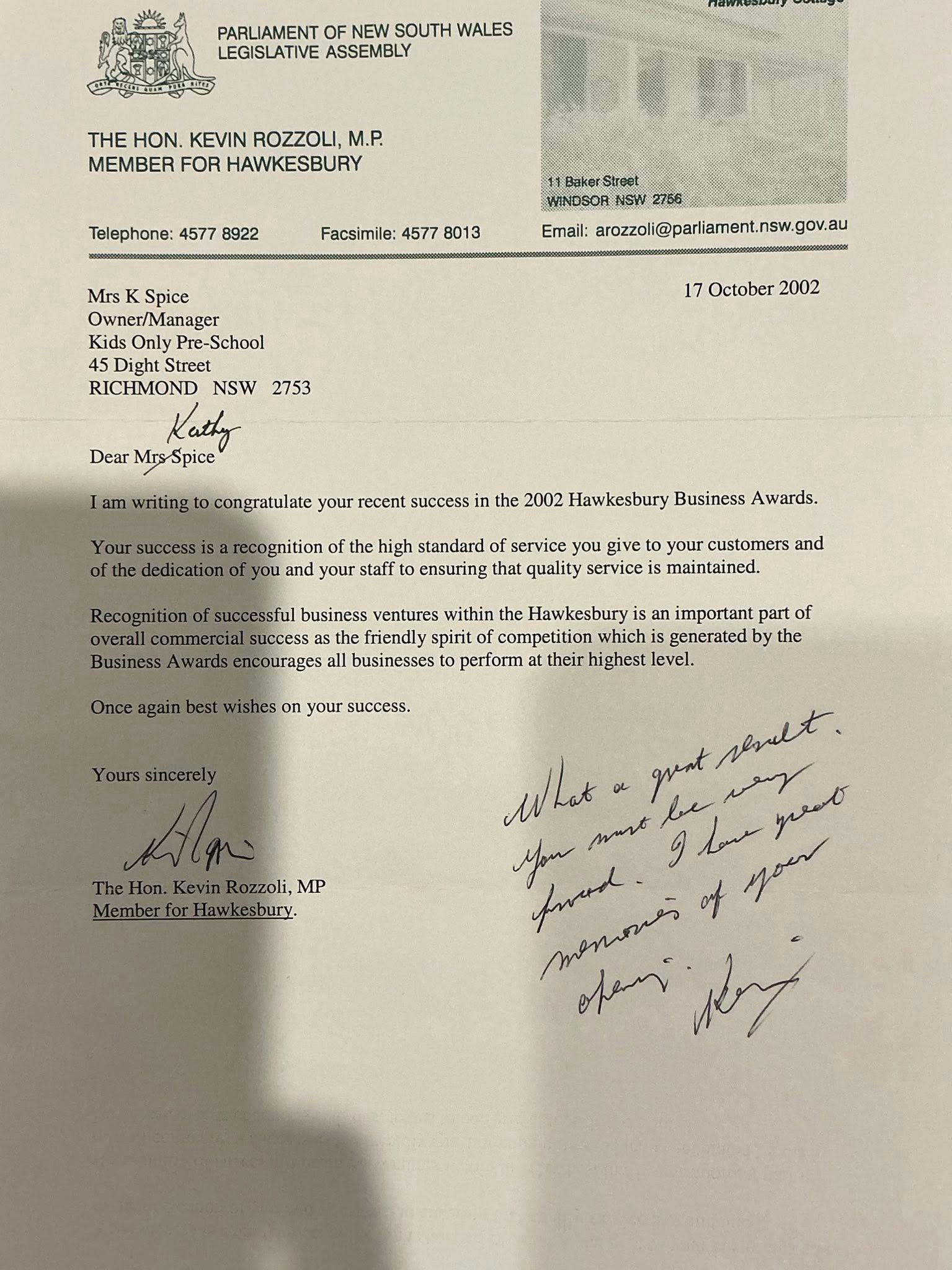Blurry photo of a typed and handwritten signed letter on white paper with a stamp at top right.