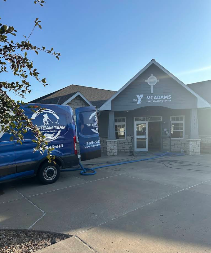 Yogurtland storefront with blue catering van parked in front on a sunny day