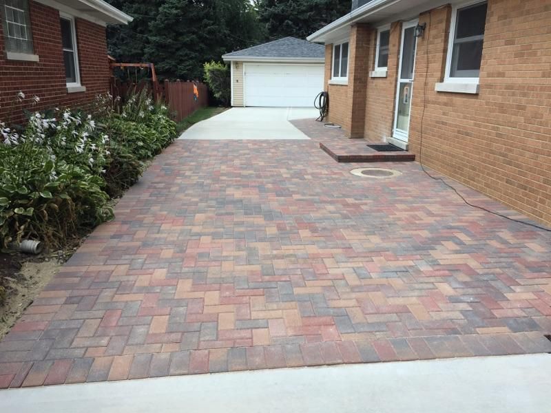 A brick driveway leading to a brick house