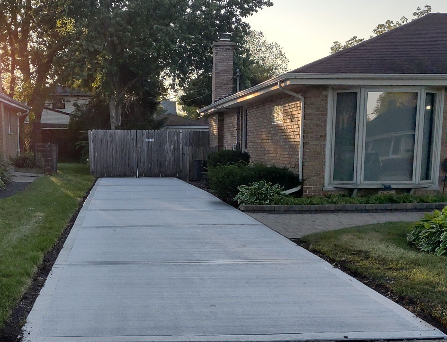 Newly paved concrete driveway leading to a brick house in Elmhurst IL