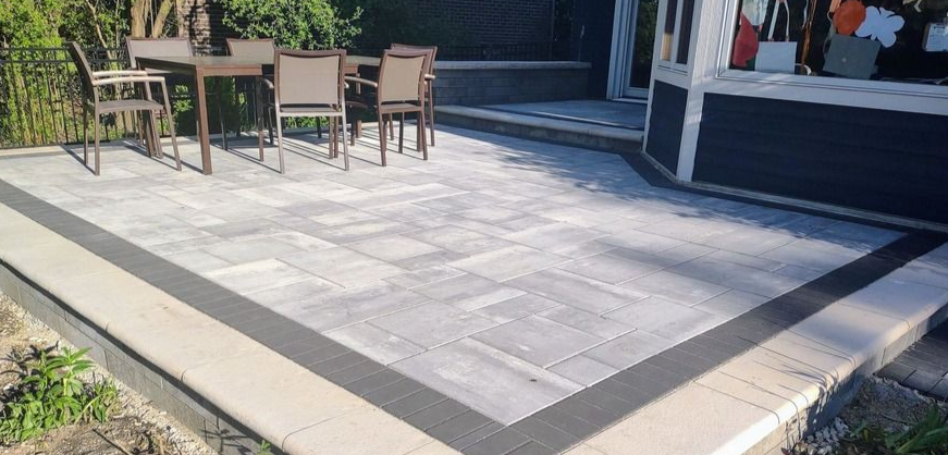 Large-format Unilock raised patio with a charcoal border near Centennial Park in Addison.