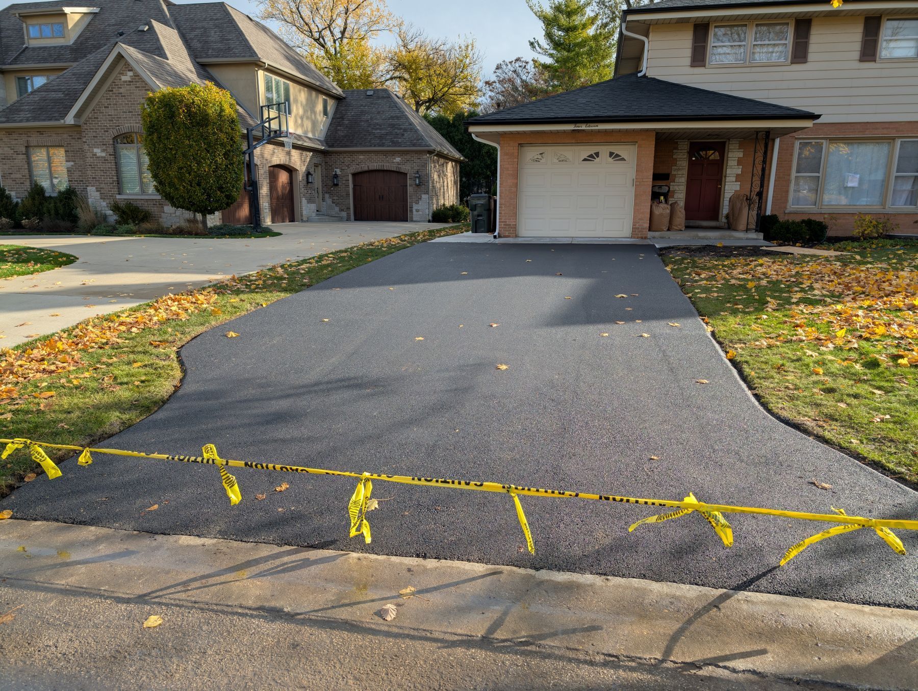 Residential driveway widened with fresh asphalt for an Addison homeowner.