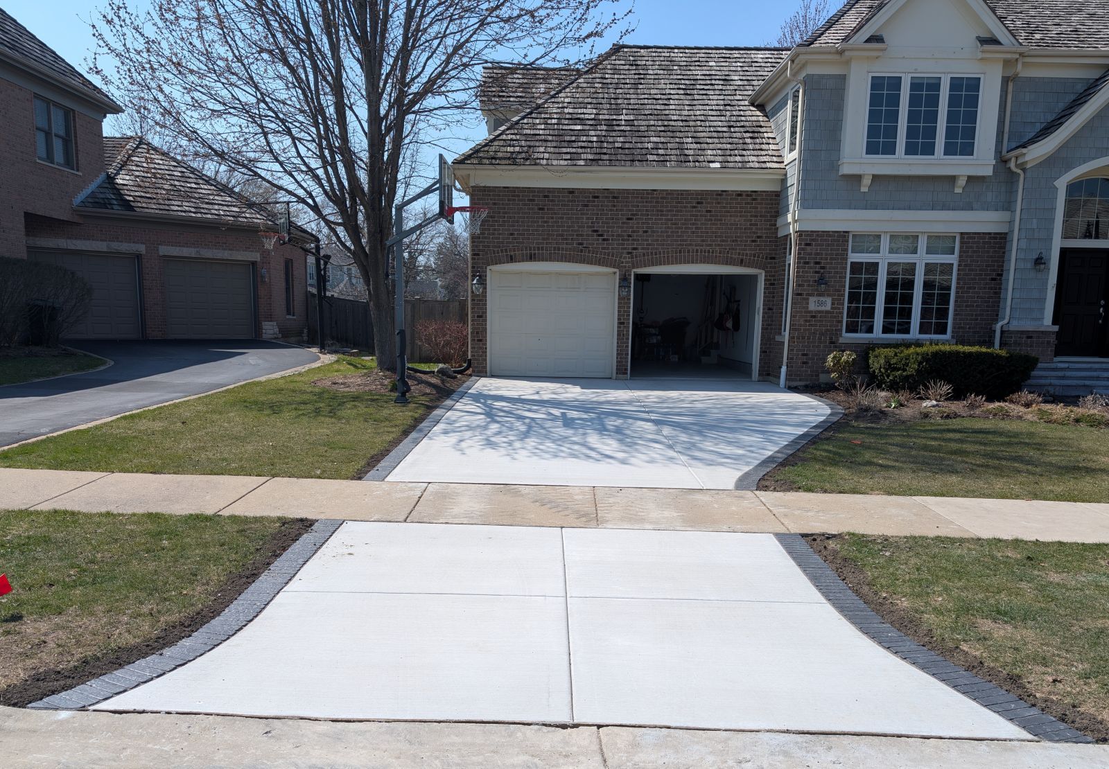 Concrete driveway featuring a decorative Unilock brick border in Addison.