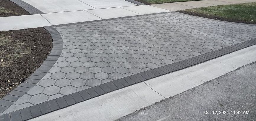 A driveway with a brick walkway and curb