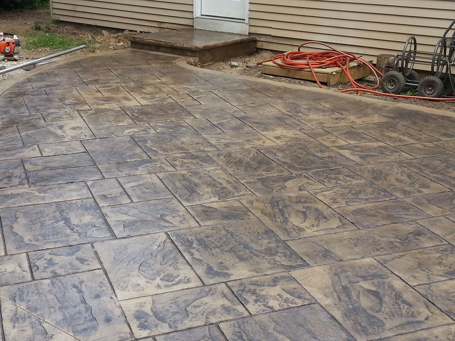Stamped concrete patio with a flagstone pattern and tools.