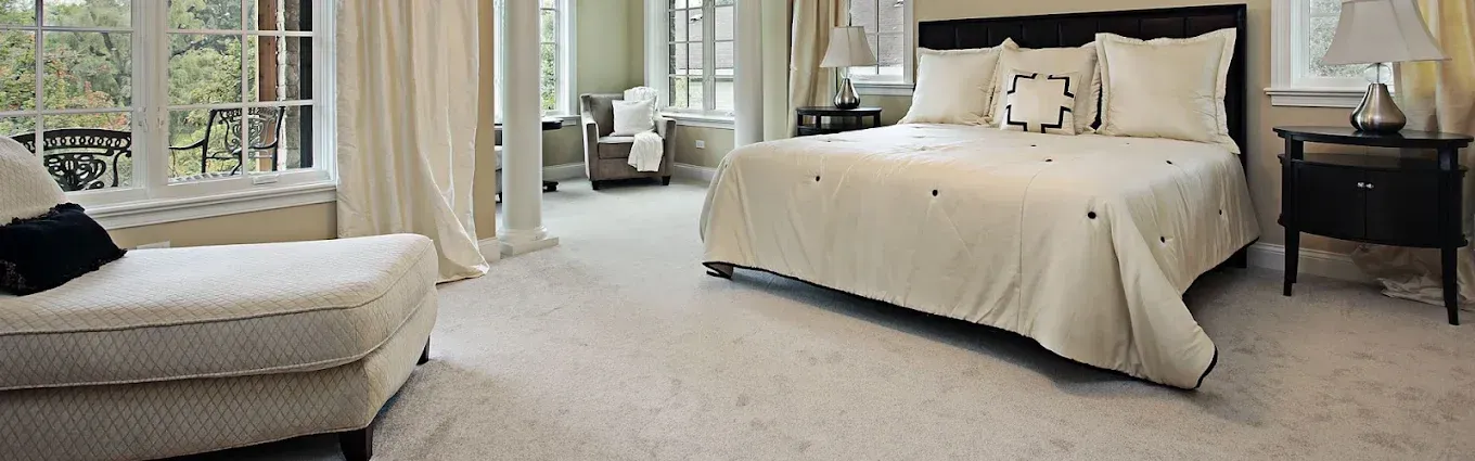 A bedroom with a bed , chair , nightstand and window.