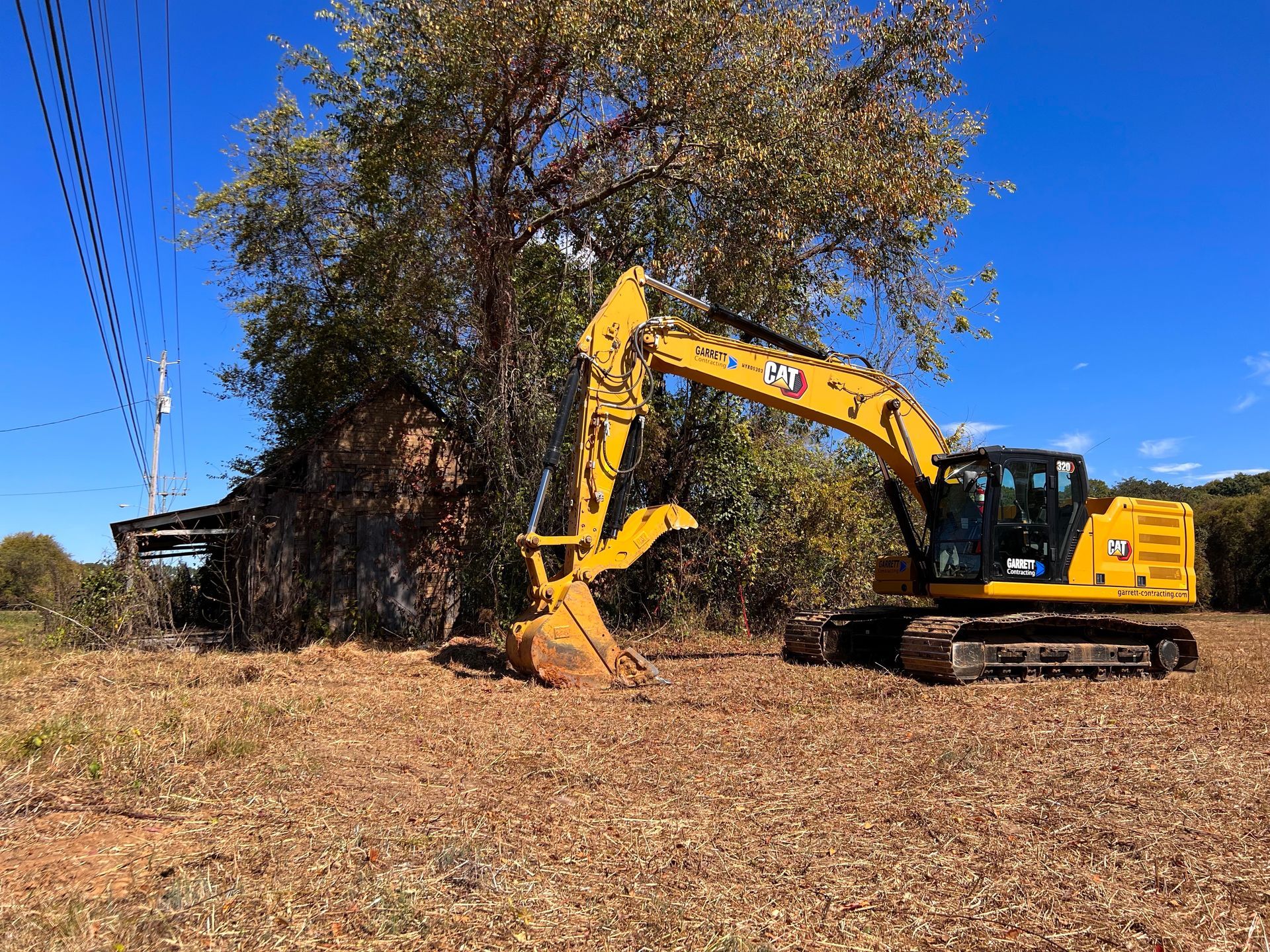Two yellow excavators on a dirt construction site under a clear sky