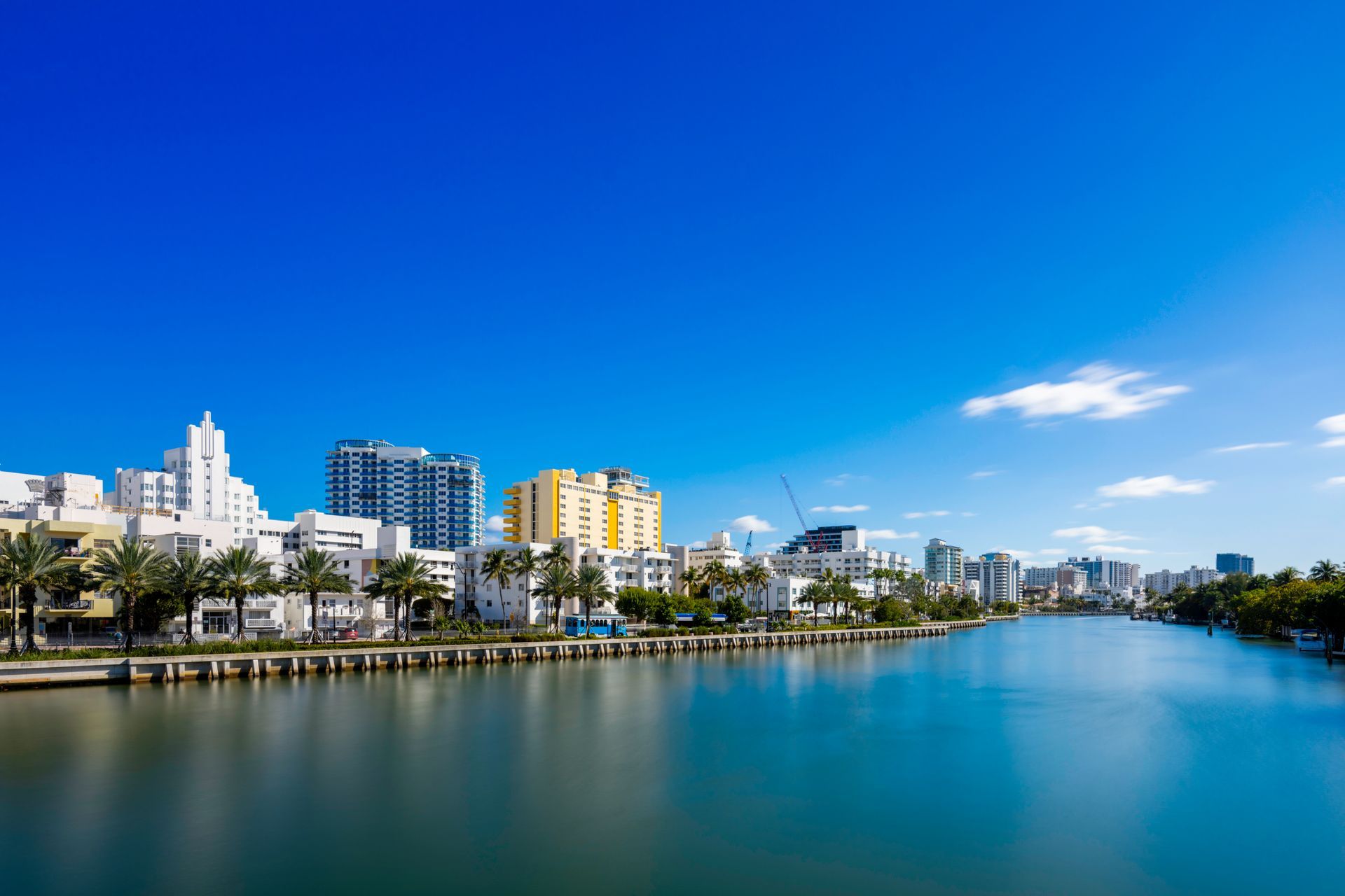 A waterfront cityscape featuring a calm body of water under a clear blue sky.