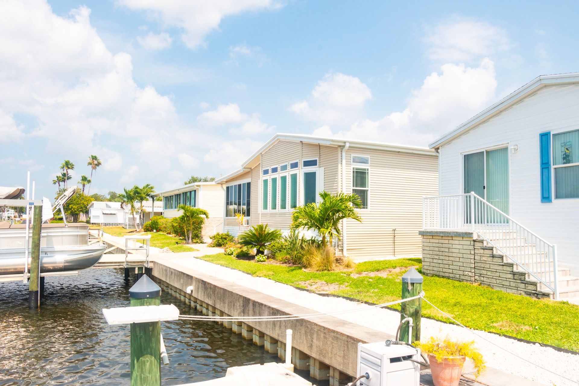 Seawall inspection at Florida waterfront mobile homes with palm trees, calm water, and clear skies. Seawall inspection at Florida waterfront mobile homes with palm trees, calm water, and clear skies.