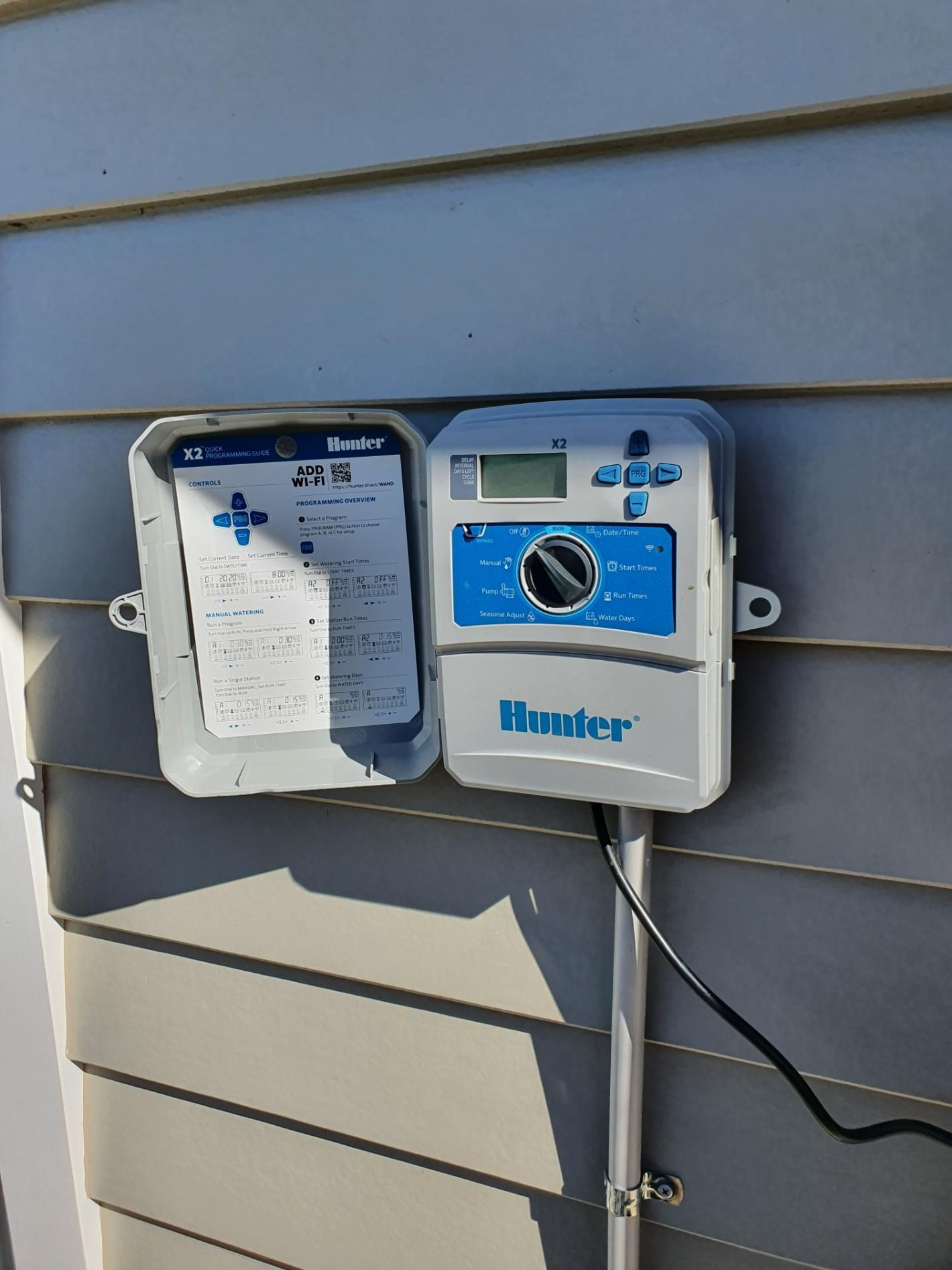 A Sprinkler Controller Is Sitting on The Side of A House — Peel Irrigation & Water Supplies in Taminda, NSW
