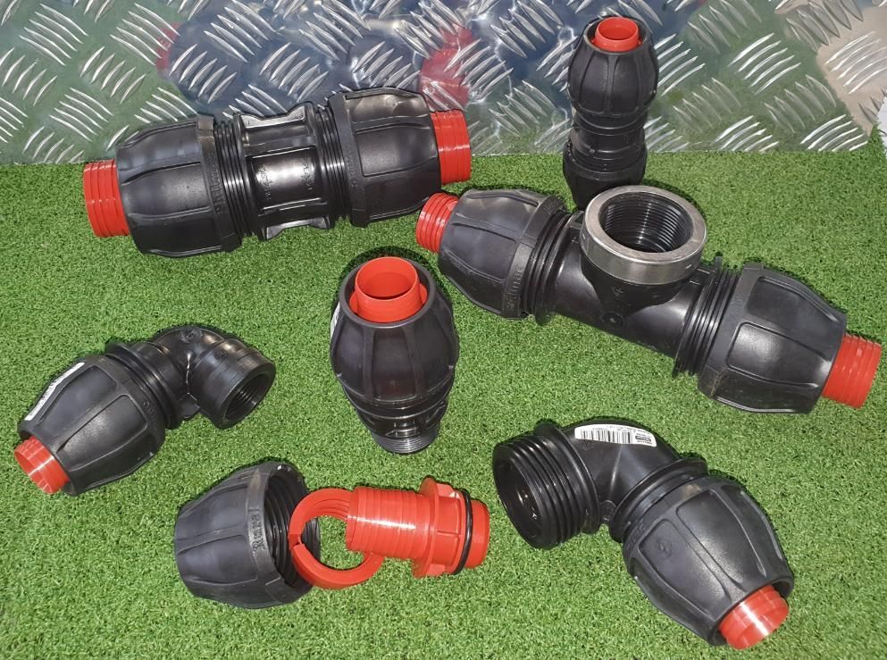Bunch of Plastic Pipe Fittings Are Laying on the Grass — Peel Irrigation & Water Supplies in Tamworth, NSW