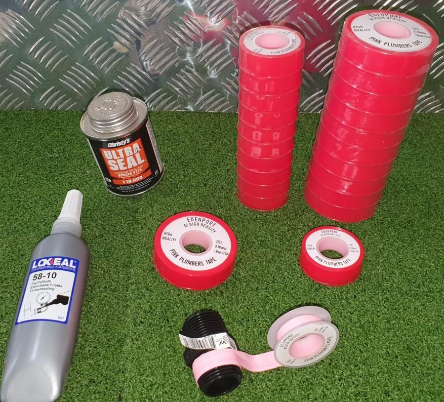 A Bunch of Rolls of Tape and A Bottle of Glue on The Grass — Peel Irrigation & Water Supplies in Taminda, NSW