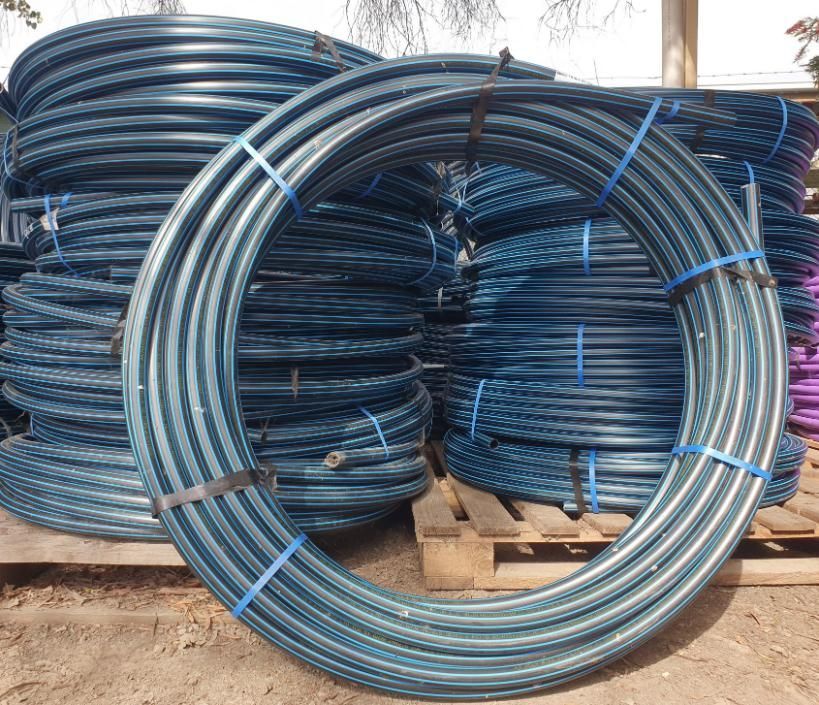 A Bunch of Blue Plastic Pipes Are Stacked on Top of Each Other on A Wooden Pallet — Peel Irrigation & Water Supplies in Taminda, NSW